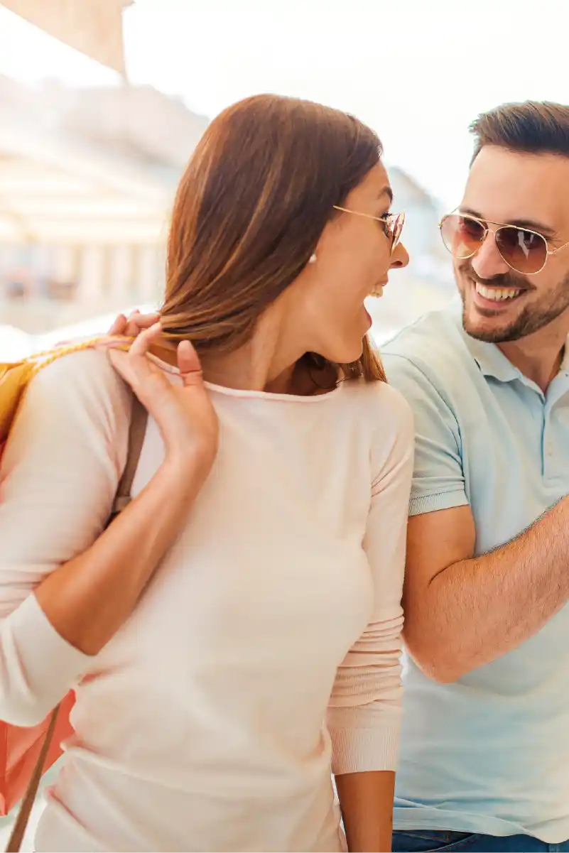 Pareja joven de compras y señalando una vitrina de una tienda