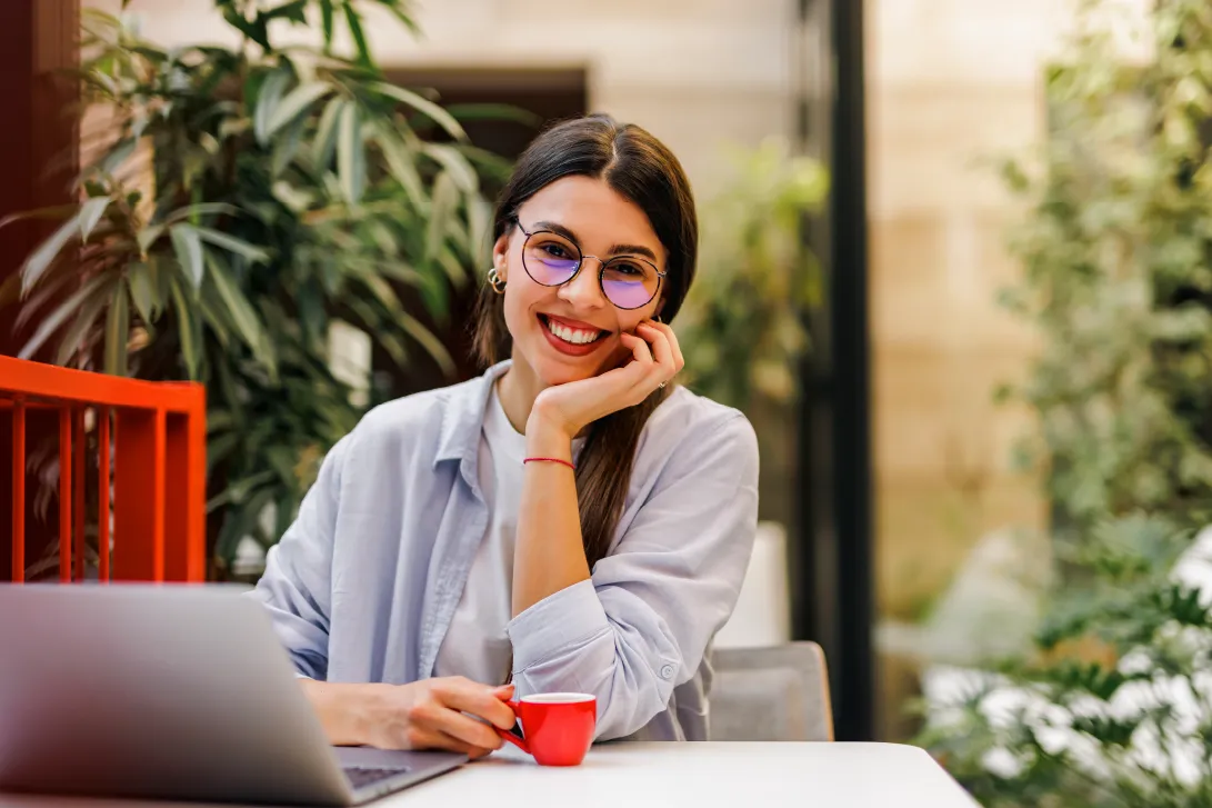 Mujer sonriente con una taza de color rojo